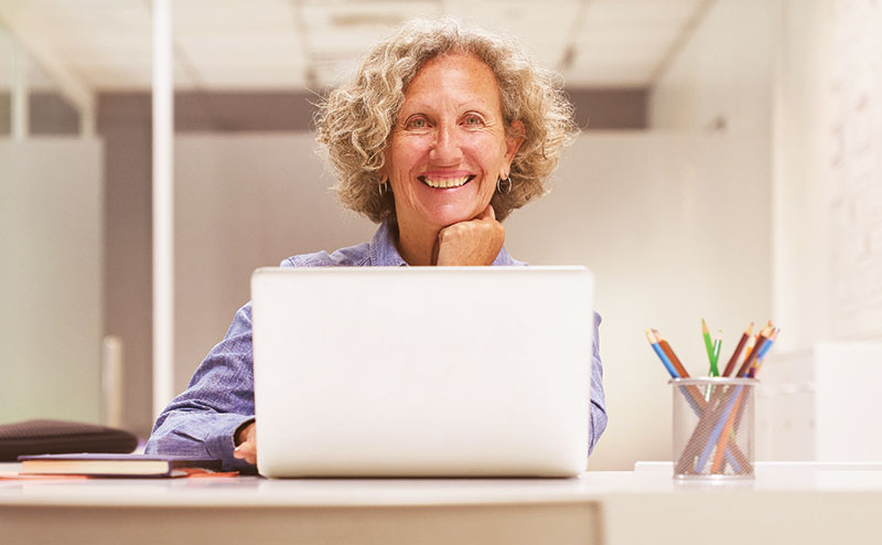 Woman sitting at a table using a laptop