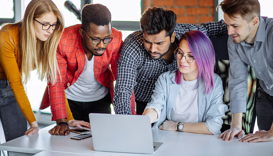 5 people all looking at the same laptop screen.