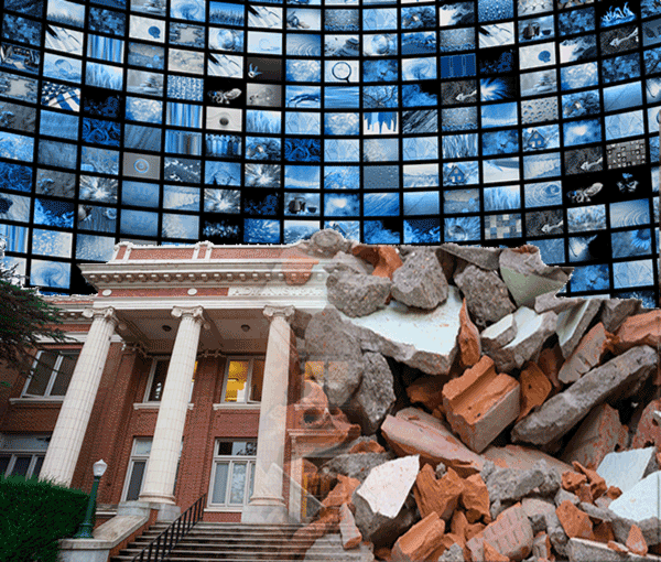 Academic building in front of a wall of screens. One side of the building is a pile of rubble.